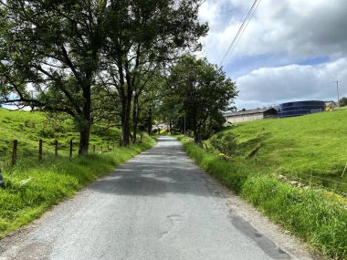 Lothersdale, Keighley, İngiltere 'de bulutlu bir günde tarlaları, ağaçları ve çiftlik evleriyle birlikte Marl Hill Lane' e bakın.