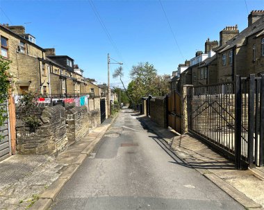 St. Marys Yolu yakınlarındaki Victoria döneminden kalma taştan evler arasında koşan arka sokak, Manningham, Bradford, İngiltere