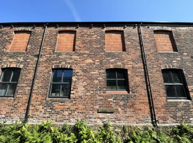 Eski Viktorya dönemi kırmızı tuğla deposu, mavi gökyüzüne karşı kurulmuş, Todmorden Yolu 'na yakın, Littleborough, İngiltere