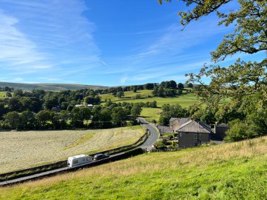 Clitheroe 'dan Skipton yoluna, eğimli tarlalar, tepeler ve ağaçlarla, Slaidburn, İngiltere