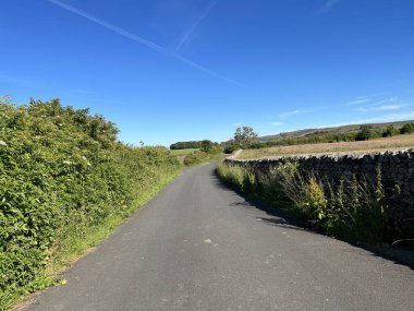 Lancashire kırsal arazisi, kuru taş duvarlar, çitler, tarlalar ve İngiltere, Slaidburn, Wood House Lane 'de mavi bir gökyüzü.
