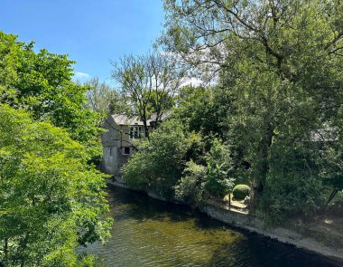 Nehir Havası 'na bakın, eski ağaçlar, taş evler ve Gargrave, İngiltere yakınlarında mavi bir gökyüzü.