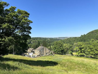 Oak Lane yakınlarındaki kırsal alanda ağaçlar, tarlalar, evler ve uzak tepeler, Sowerby Köprüsü, İngiltere