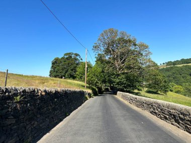 Aşağı bak, Oak Lane, kuru taş duvarlar, tarlalar ve ağaçlarla, mavi gökyüzüne karşı, Sowerby Köprüsü, İngiltere