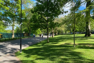 Park manzarası, kırık güneş ışığı, eski ağaçlar, ve tenis kortları, Lister Park, Bradford, İngiltere