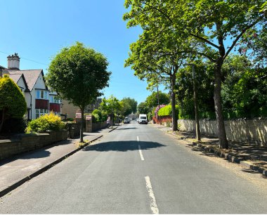 Grasmere Yolu 'nda eski ağaçlar, bahçeler, evler ve Gledholt, Huddersfield, İngiltere' de mavi gökyüzü olan sakin bir yerleşim yeri.
