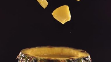 Ananas parçaları yavaş çekimde yarım ananasın yüzeyine düşer. Yüksek kalite 4k görüntü