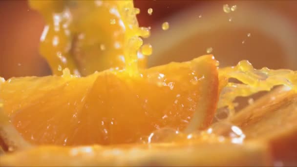 オレンジジュースの超スローモーションが1000Fpsでオレンジのスライスを飛び越える — ストック動画