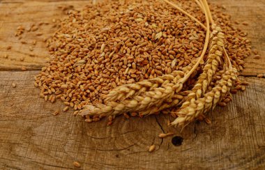 Ahşap zemin üzerinde kahverengi buğday kulakları.