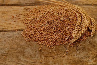 Ahşap zemin üzerinde kahverengi buğday kulakları.