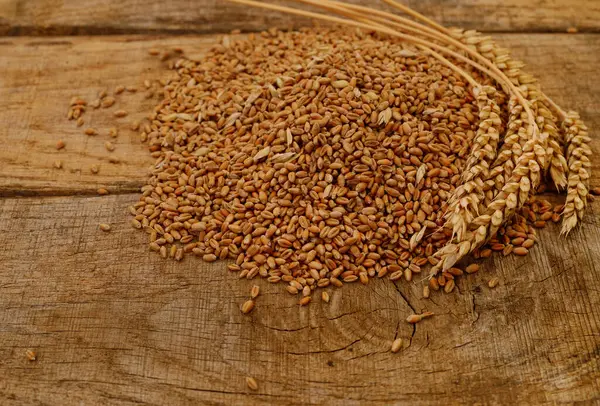 Ahşap zemin üzerinde kahverengi buğday kulakları.