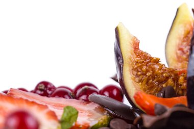 Kek süslemesi yakın, taze böğürtlen, çilek, incir, üzüm, dere ve çikolata ile süslenmiş, beyaz arka planda izole edilmiş.