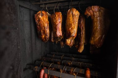 Tütsülenmiş et, göbek ya da kayın etini tütsüleme evinde ya da tütsüleme odasında, yiyecek kavramında kapayın.