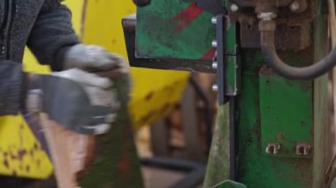 Woodworking production, worker using heavy saw to produce a lumber planks or firewood, woodworking equipment concept