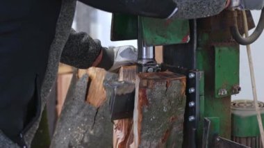 Woodworking production, worker using heavy saw to produce a lumber planks or firewood, woodworking equipment concept