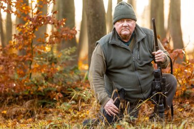 Avcı ya da korucu portresi av silahı ve avlanma biçimi ile sonbahar ormanlarında avlanmak, avlanma konsepti