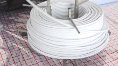 Installing underfloor heating white pipes for water heating, heating systems, white pipes for heat insulated floor, industrial concept