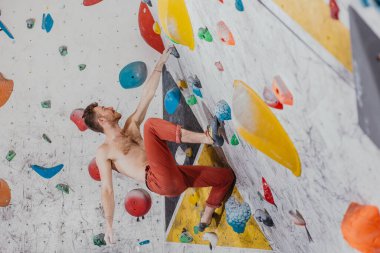 Genç dağcı evin içindeki kaya duvarına tırmanıyor, dikiz manzarası, ekstrem sporlar ve kayalar konsepti