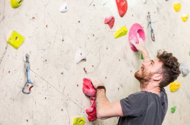 Genç dağcı, kaya duvarına tırmanıyor. İç mekan, dikiz aynası, ekstrem spor ve kaya döşeme konsepti.