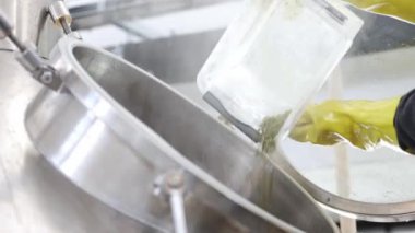 Bira fabrikasındaki biraları demlemek için paslanmaz çelik tanka kurumuş, granüle zıpzıplar, bira demleme konsepti.