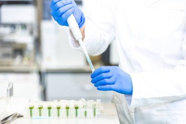 Bilim laboratuarında damlatan sıvıyı bir test tüpüne damlatan bilim adamı, ilaç çevresi kavramı