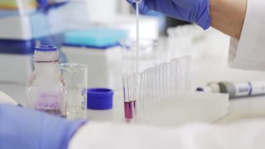 Genç bilim adamı ya da tıbbi teknisyen cam şişede yeni eczane ilaçları geliştiriyor. Klinik bir laboratuvarda, ilaç araştırmaları ve araştırma konseptinde.