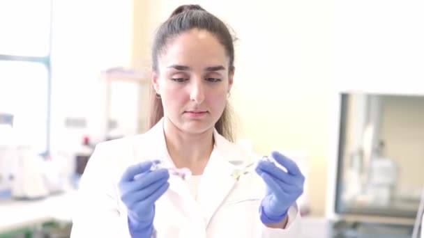 在临床实验室的玻璃瓶中研发新药的年轻科学家或医疗技术人员 药物研究的概念 — 图库视频影像