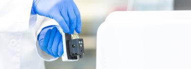 Genç bir bilim adamı ya da tıp teknisyeni klinik laboratuarında cam şişede yeni eczacılık ilaçları geliştiriyor.