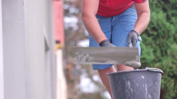 男工用胶水或胶粘剂涂在房屋的正面 房屋的绝缘上 — 图库视频影像