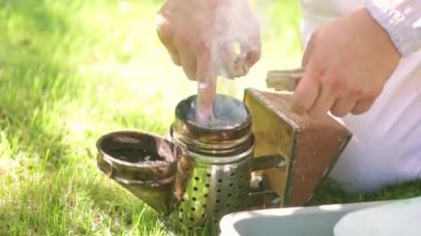 Arı yetiştiricisi arıcılık konsepti olan arı kovanına sigara hazırlıyor.