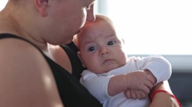 Anne ve bebek evde birbirlerine sarılıyorlar, ebeveyn sevgisi kavramı.