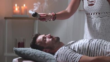 Kadın şifacı, yanan bir adaçayı ile aromaterapi yapıyor, alternatif bir ilaç.