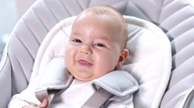 Yeni doğmuş bebek gülüyor ve gülümsüyor, şirin bir durum, bebeğin olumlu duyguları, sağlık sigortası konsepti