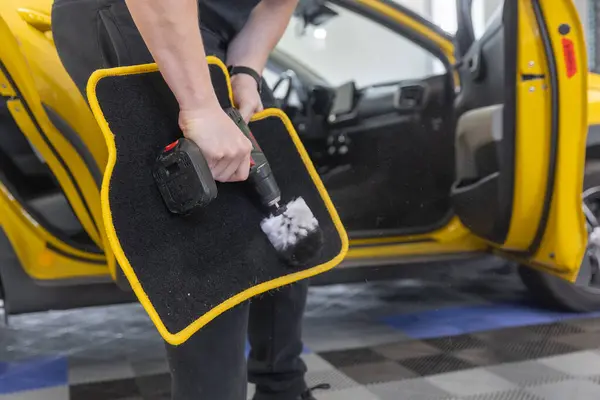Process of cleaning car mat by an automatic brush cleaner, car detailing concept