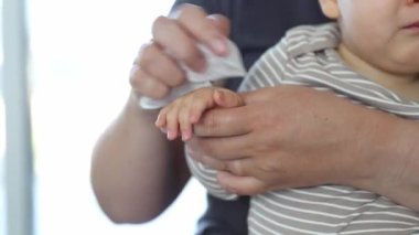 Mumya bebek ellerini antibakteriyel mendille temizliyor, sağlık hizmeti konseptiyle.