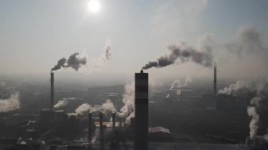Endüstriyel bacalardan yükselen duman güneş doğarken atmosferi kirletir.