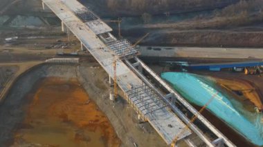 İnşaat işçileri nehir üzerinde bir otoyol üstü köprü inşa ediyorlar.