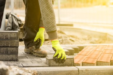 İnşaat işçisi bir yerleşim bölgesine gri beton döşeme döşeme döşemesi yapıyor.