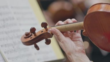 Orkestra provası sırasında müzisyenlerin ellerini keman çalarken kapatın.