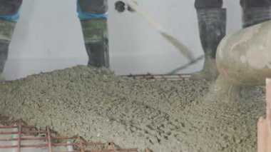 İşçiler inşaat sahasına ustalıkla taze beton dökerek binanın düzgün ve pürüzsüz temelini sağlıyorlar.