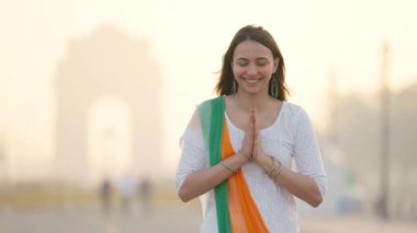 Indian girl doing Namaste and greetings in Indian white Kurti and tri-color scarf