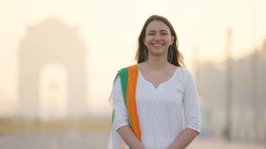 Happy Indian woman standing in an Indian traditional outfit at India gate, celebrating Republic day