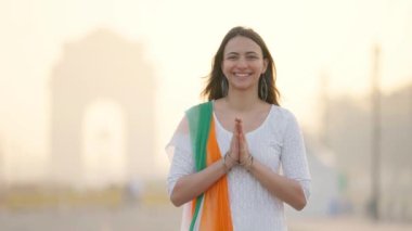 India girl greeting and doing Namaste in Indian outfit at India gate