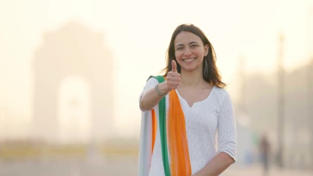一个快乐的印度女孩穿着一套印度服装在印度大门口德里附近给Thumbs表演 — 图库视频影像