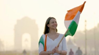 Proud Indian girl looking towards the Indian flag at the celebration of Independence day at India gate Delhi