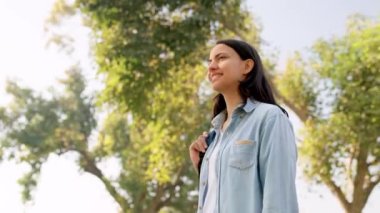 Beautiful and confident Indian girl looking towards trees and sky