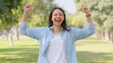 Happy Indian girl cheering and energizing herself in a park