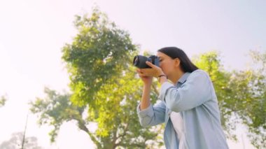 Indian girl clicking photos of nature for her college assignment using a camera