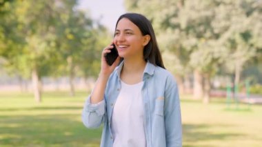 Happy Indian girl talking on phone to her boyfriend