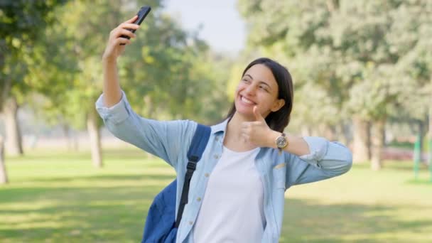 漂亮的印度女孩使用手机在社交媒体应用程序上上传自己的照片 — 图库视频影像